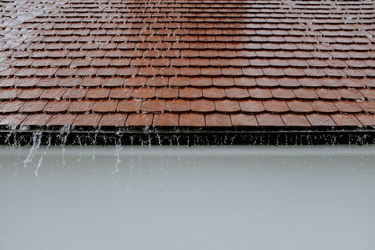 Water overflowing from a roof without proper downspout drainage