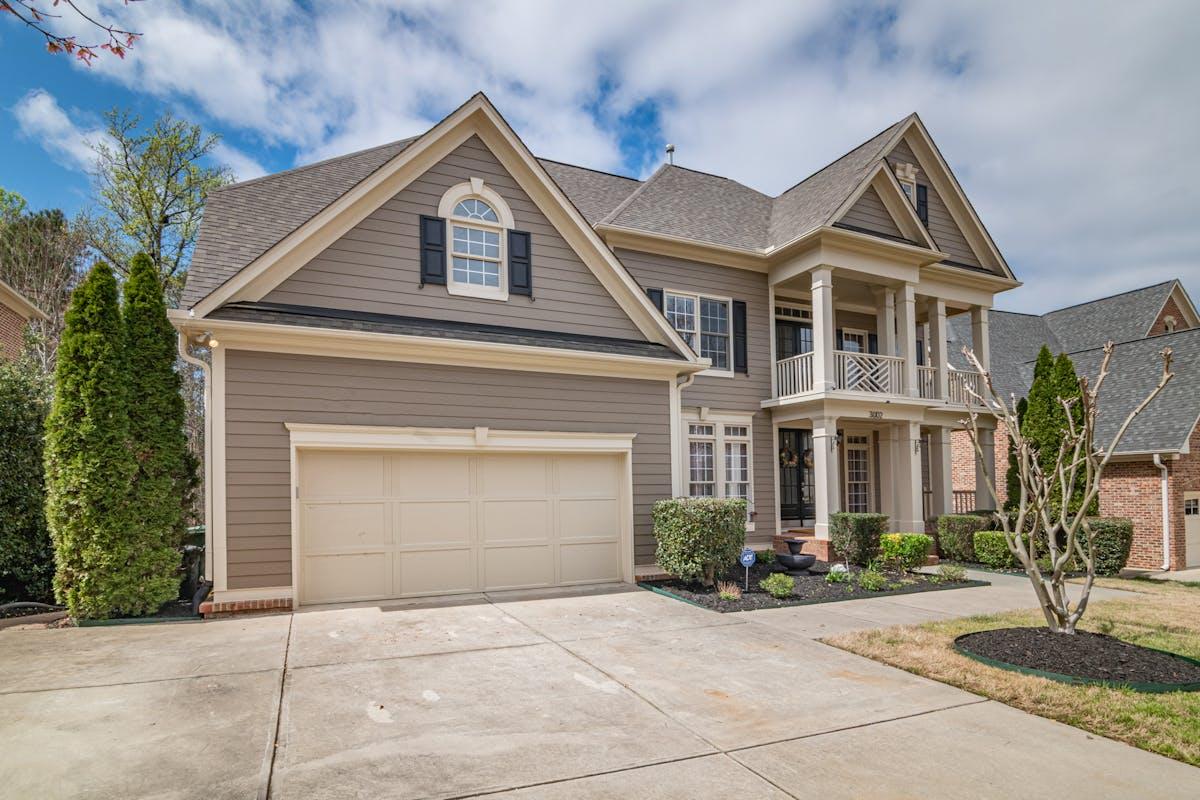 Two-story home with traditional tan vinyl siding